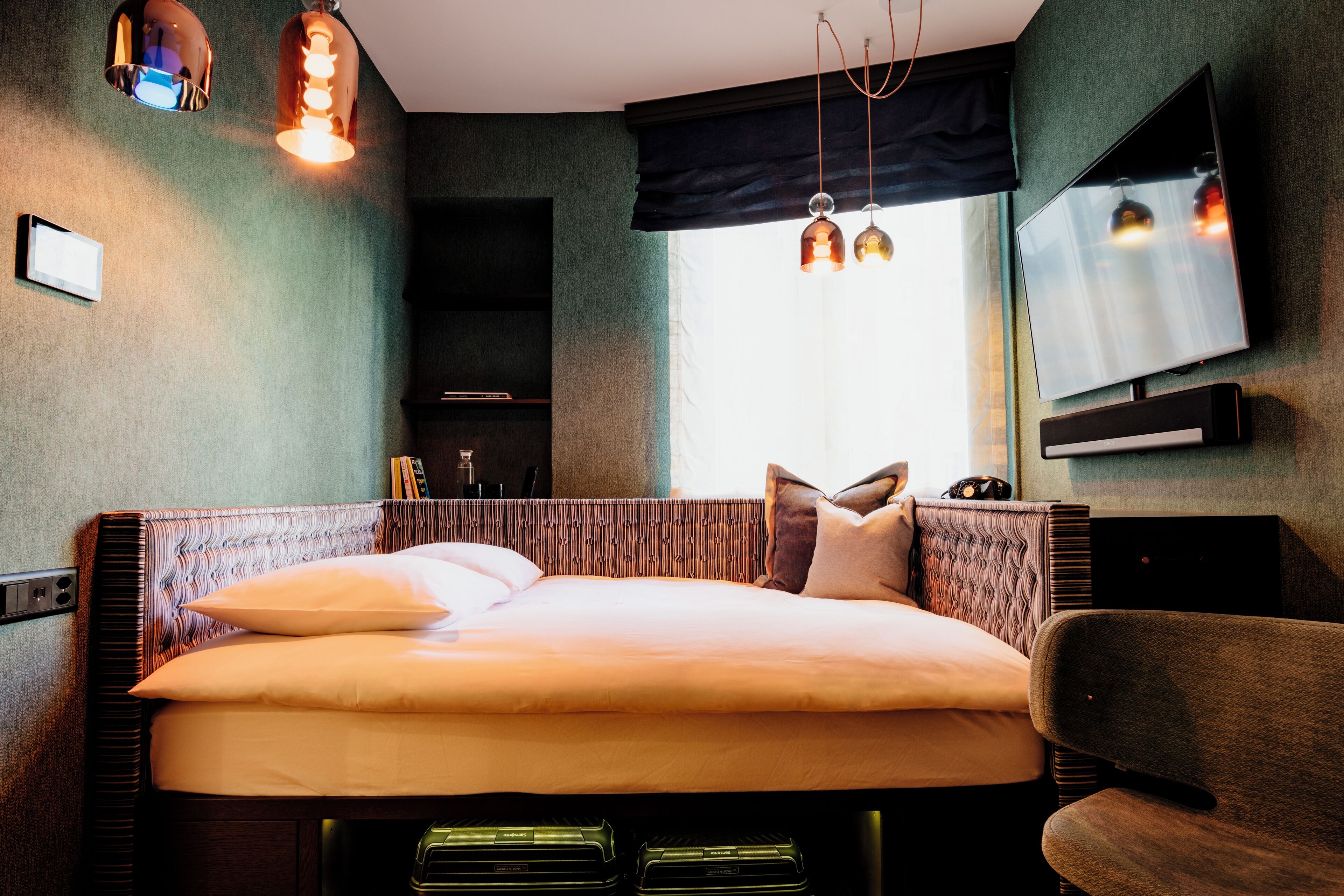 A modern hotel room with a large bed, a flat-screen TV, and ambient lighting.