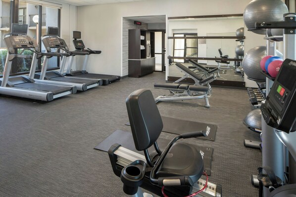 A gym with treadmills, a stationary bike, and various exercise equipment.