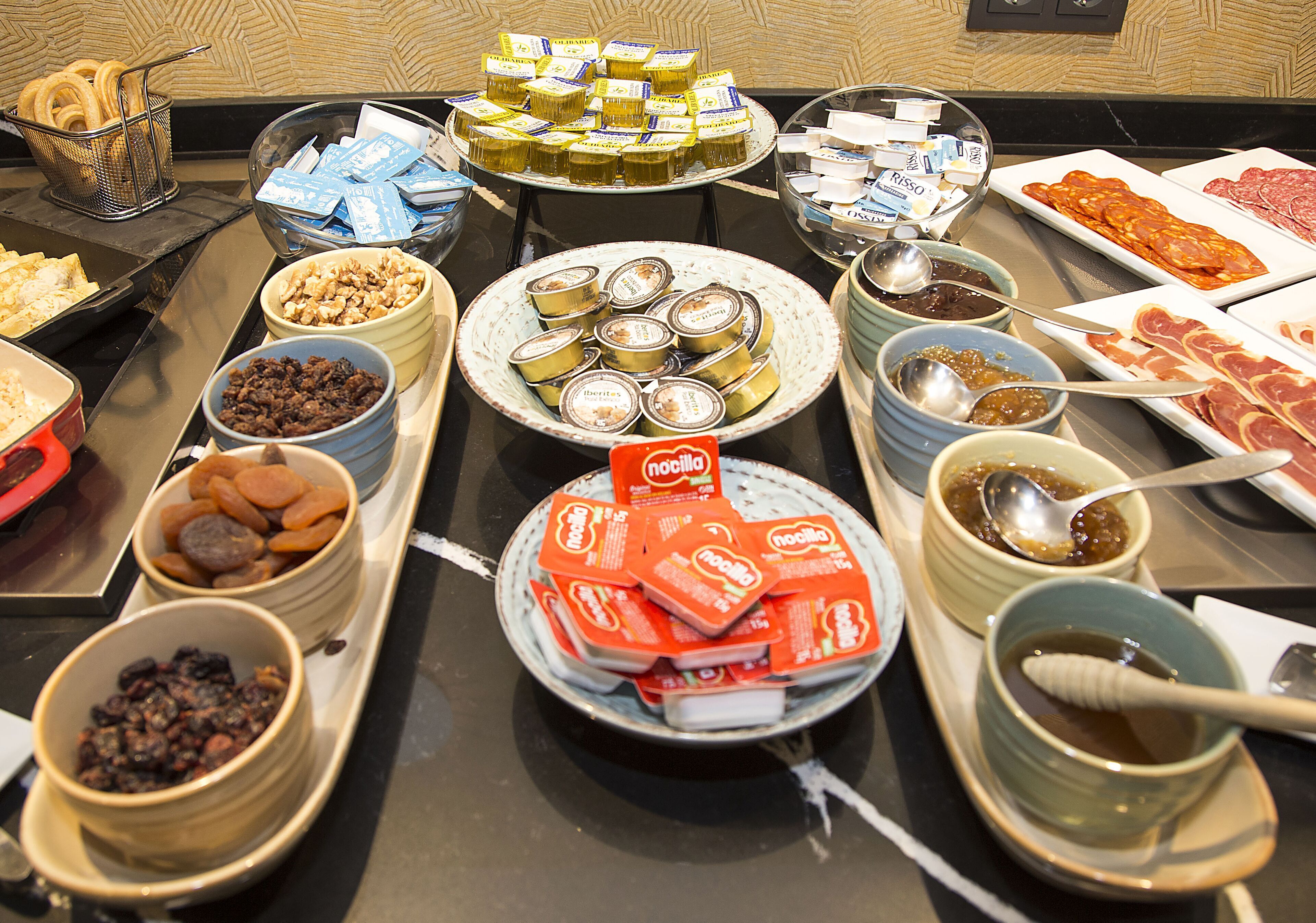 A buffet with various food items including nuts, dried fruits, canned goods, and condiments.