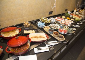 A buffet with various dishes and condiments.