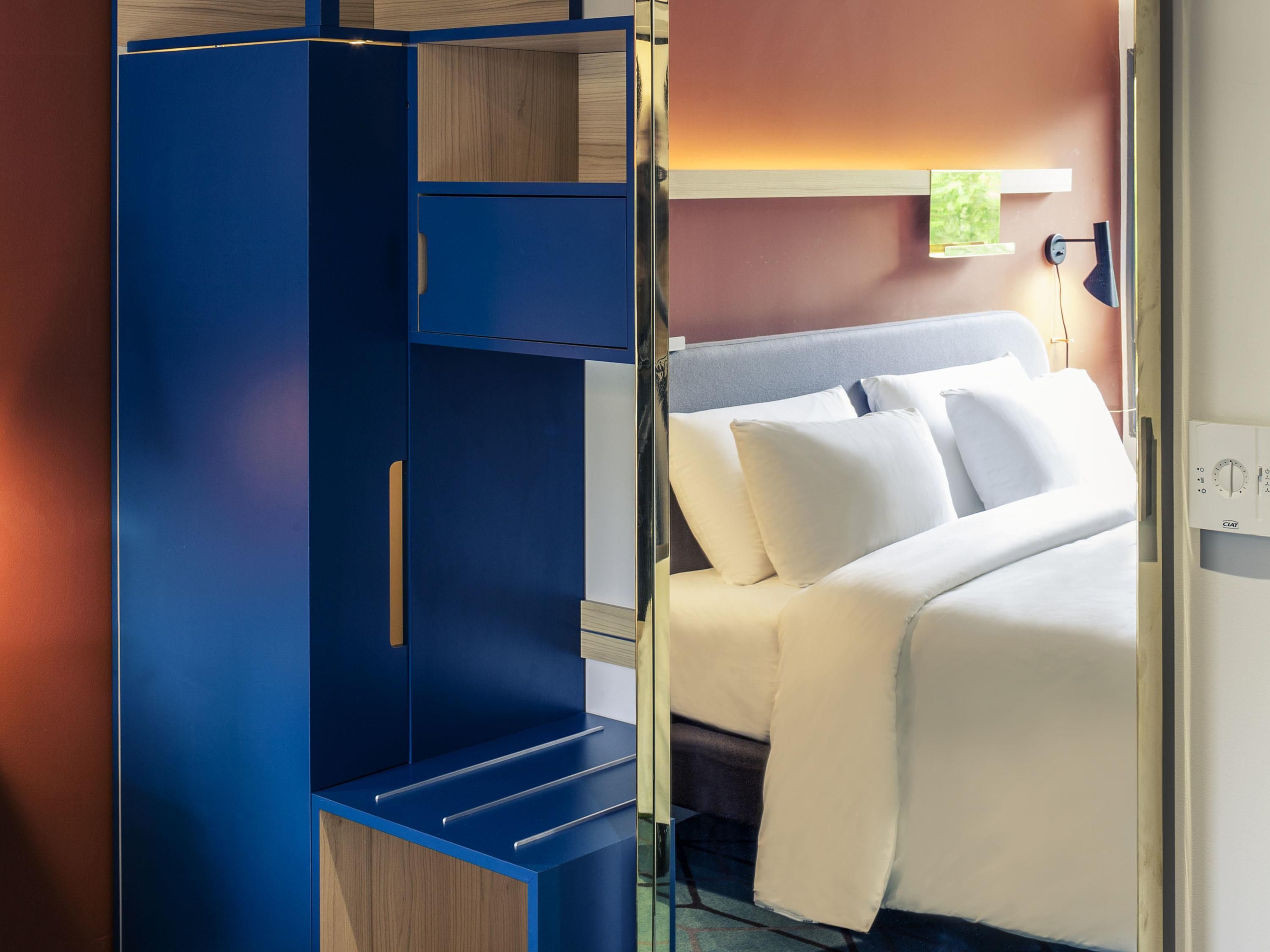 A bedroom with a bed, a wardrobe, and a nightstand.