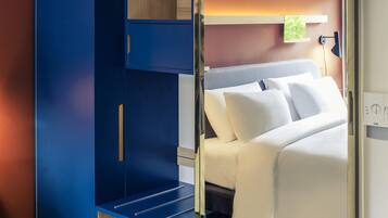 A bedroom with a bed, a wardrobe, and a nightstand.