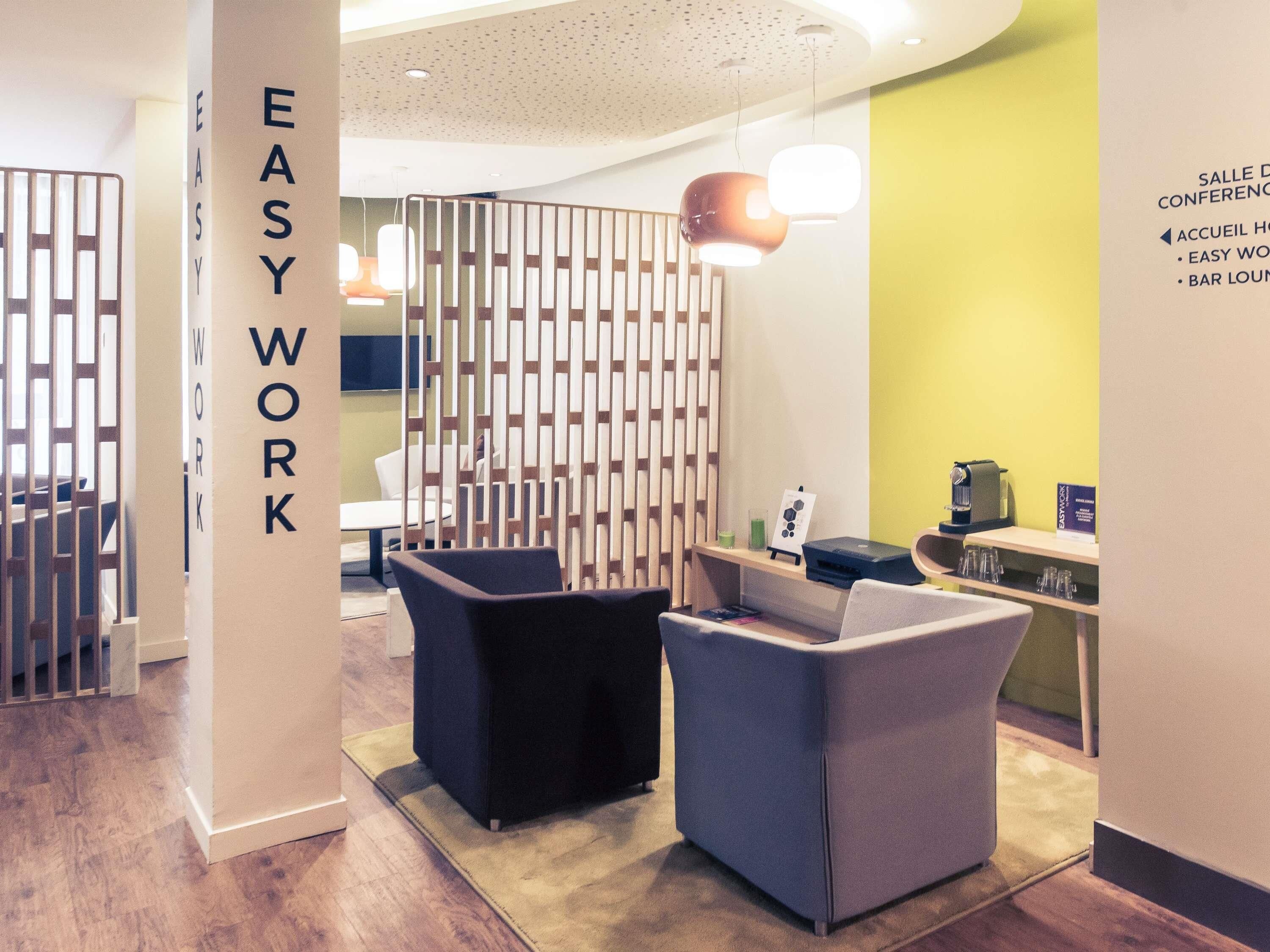 A modern lounge area with seating and a reception desk.