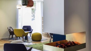 Een moderne woonkamer met een open haard, comfortabele zithoek en uitzicht op de omgeving.