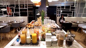 Een buffet met diverse gerechten, drankjes en bestek.