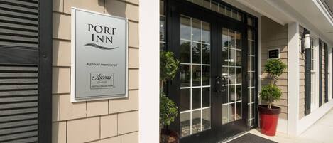 A hotel entrance with a sign reading "PORT INN" and "A proud member of Ascenda Hotel Collection."