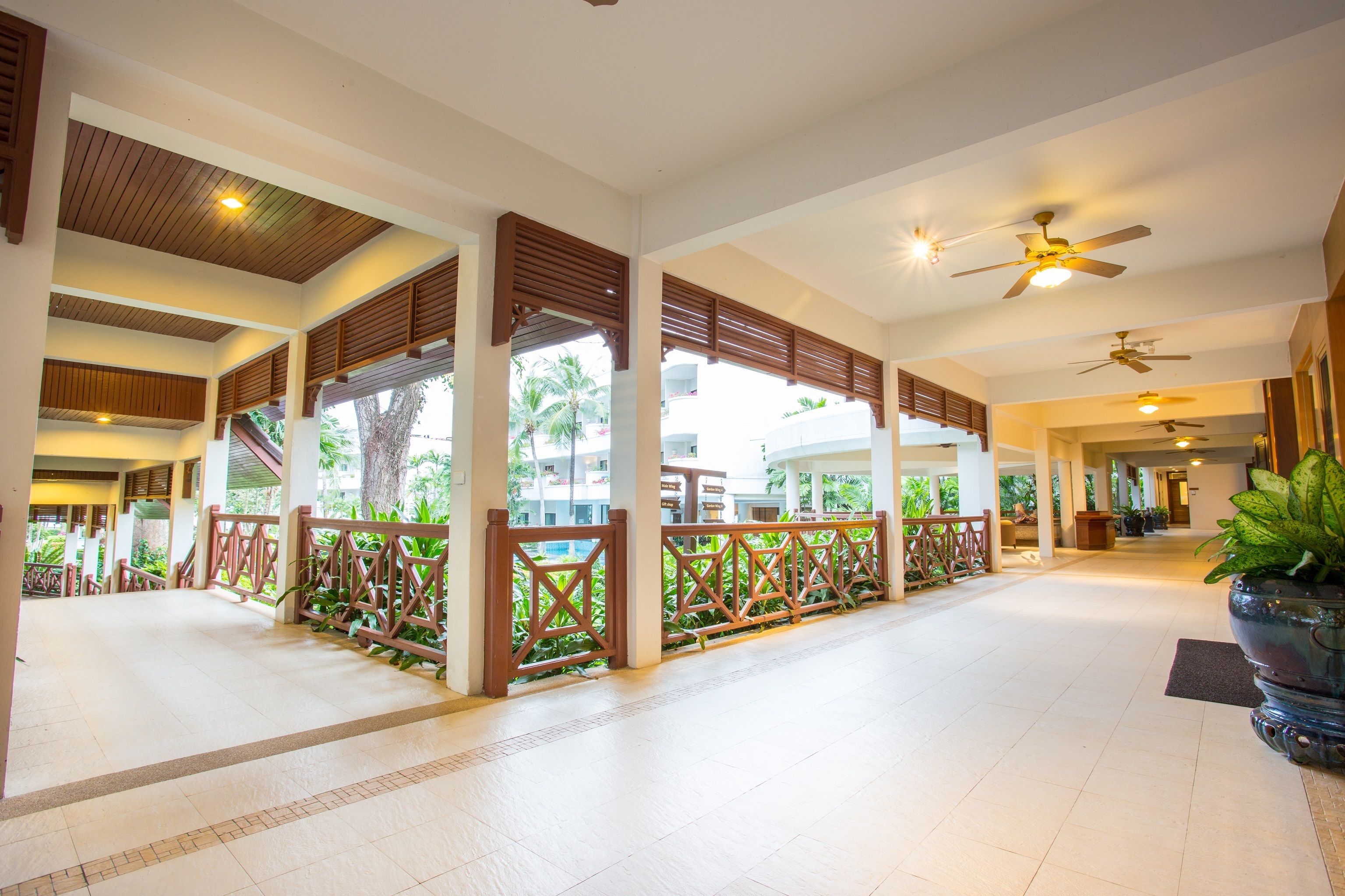 A spacious indoor area with a high ceiling, wooden railings, and ceiling fans.
