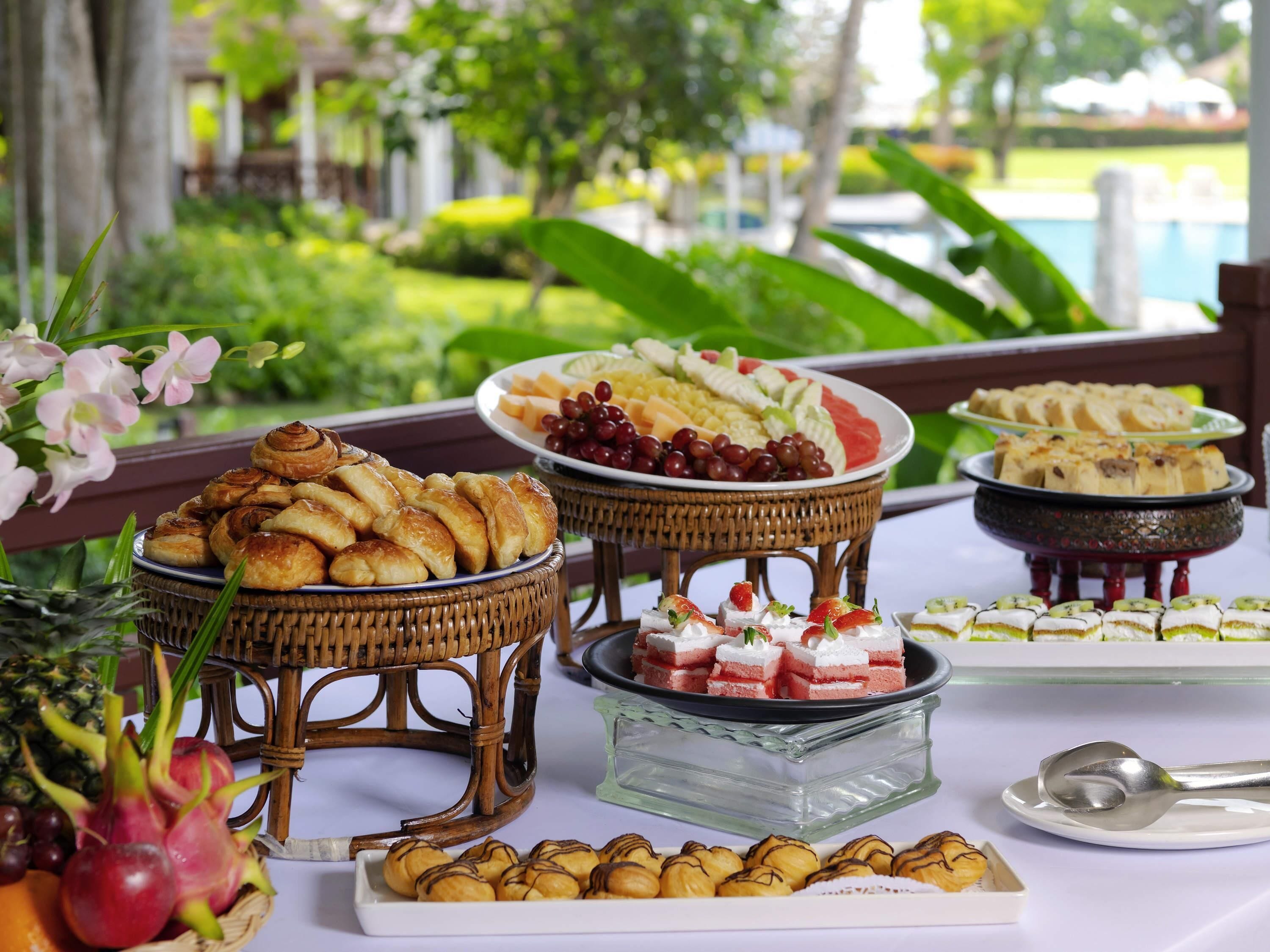 A buffet with various food items including pastries, fruits, and desserts.