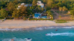 An aerial view of a resort with a large pool, beachfront, and boats in the water. - Novotel Rayong Rim Pae Resort (Klaeng)