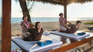 A beachside yoga session with mats and pillows on wooden platforms, overlooking the sea. - Novotel Rayong Rim Pae Resort (Klaeng)