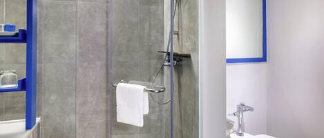Un baño moderno con ducha de mampara de vidrio, inodoro blanco y espejo con marco azul.