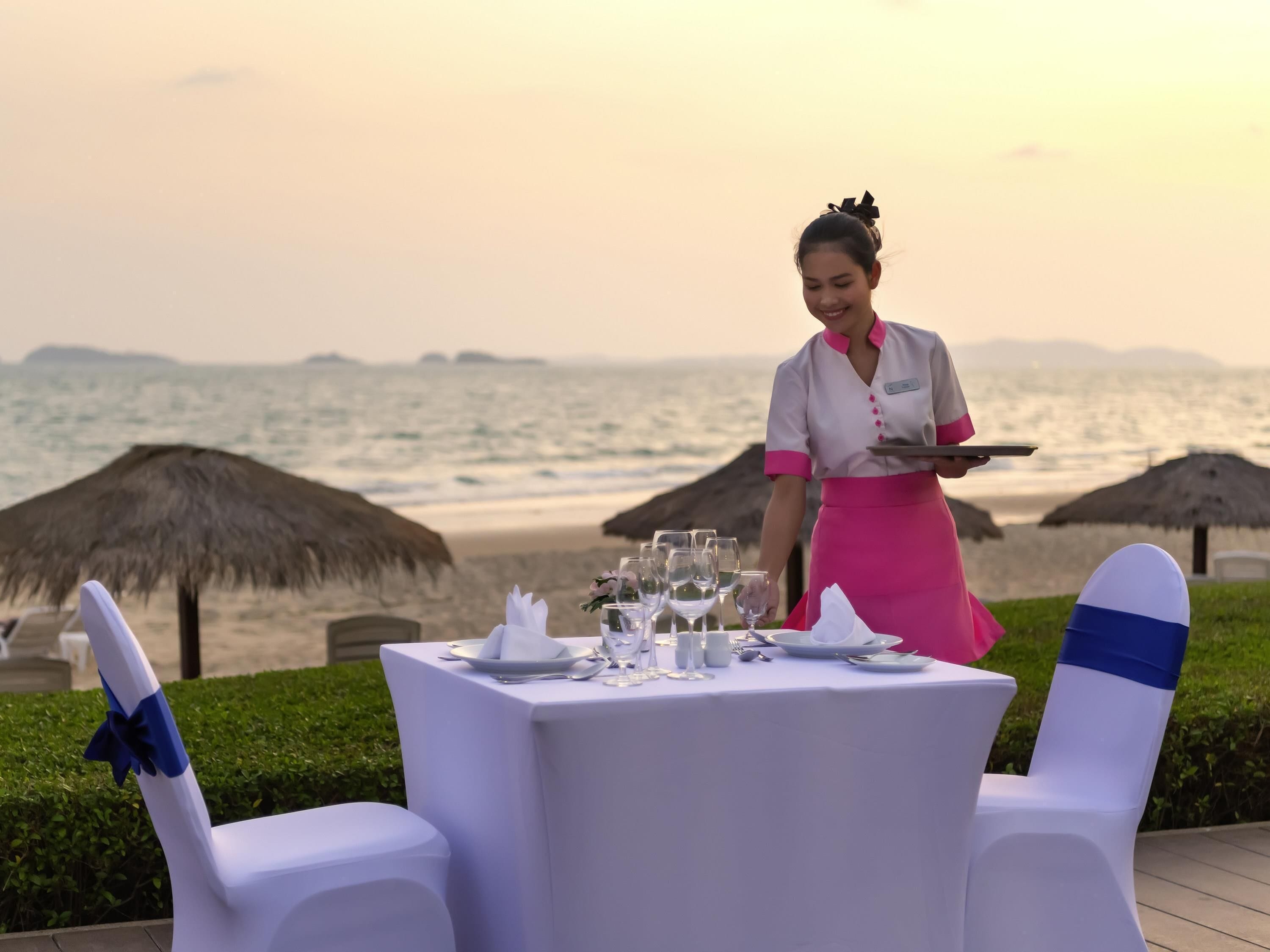 A table set for dining with a view of the ocean.