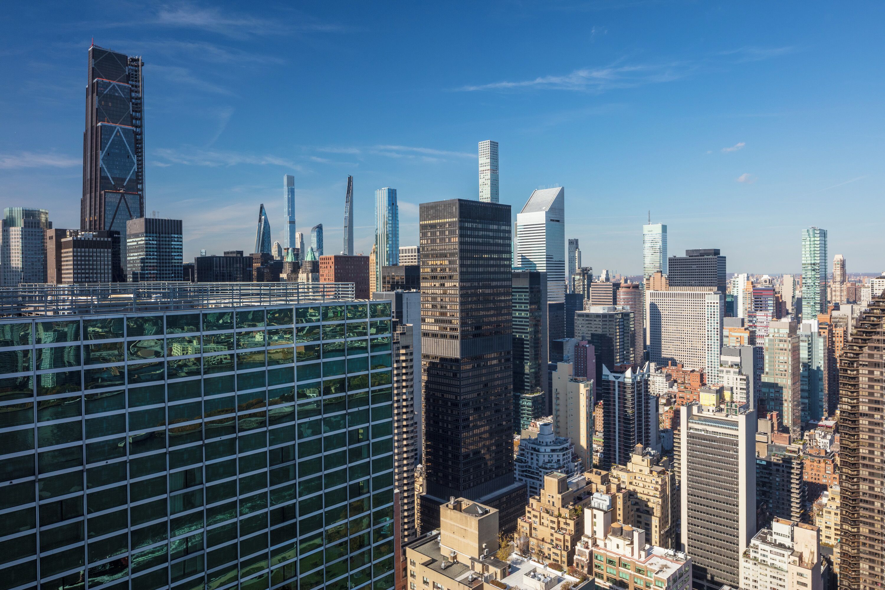 A high-rise cityscape with modern skyscrapers and a prominent glass building.