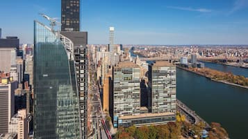 Ein Hochhaus mit moderner Glasfassade, umgeben von weiteren hohen Gebäuden und einem Fluss.