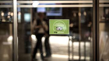 Une porte vitrée ornée d’un autocollant attestant de l’obtention du certificat d’excellence de TripAdvisor.