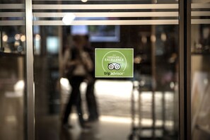 A glass door with a TripAdvisor Excellence Certificate sticker.