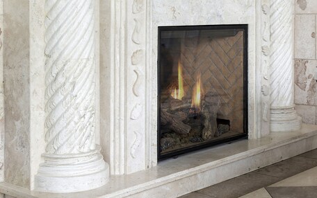 A fireplace with a stone mantle and classical columns.
