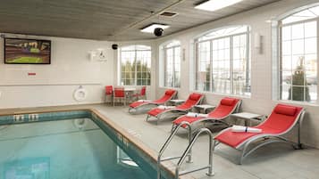 Un área de piscina con sillones de descanso y un ventanal grande.