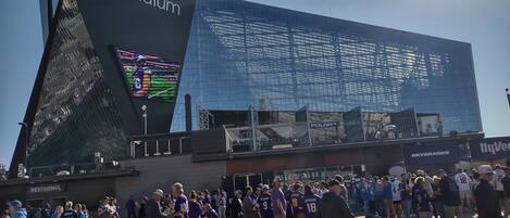 A stadium with a large digital screen, a crowd of people, and a sign for 'BEVERAGES'.