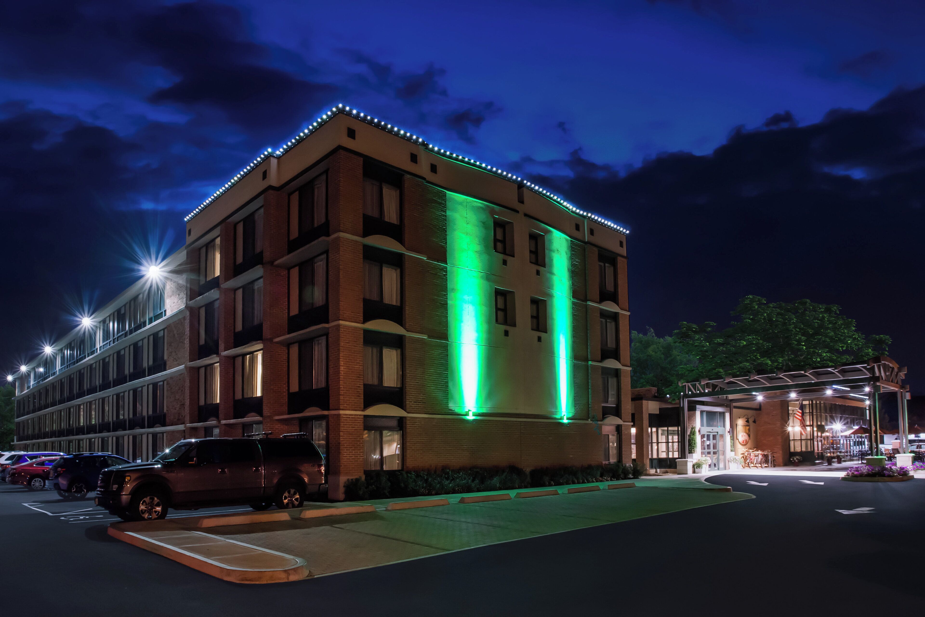 Hotel com vários andares, estacionamento e área externa coberta.
