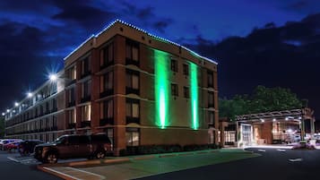 Hotel com vários andares, estacionamento e área externa coberta.