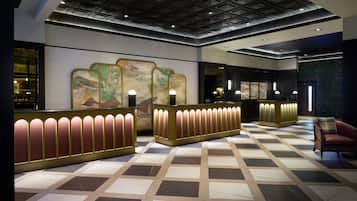 Un vestíbulo de hotel con mostrador de recepción, área de espera y asientos.