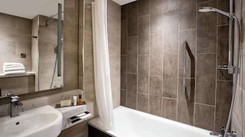 Un baño moderno con bañera, ducha y lavabo.