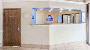 A reception area with a Days Inn sign, a wooden door labeled "Employee Only," and a glass door leading inside. - Days Inn by Wyndham San Antonio Splashtown/ATT Center (San Antonio)