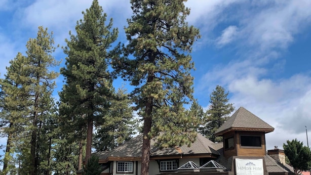 A two-story building with a prominent 'HiMark Hotel' sign, large windows, and a stone facade. - HiMark (South Lake Tahoe)
