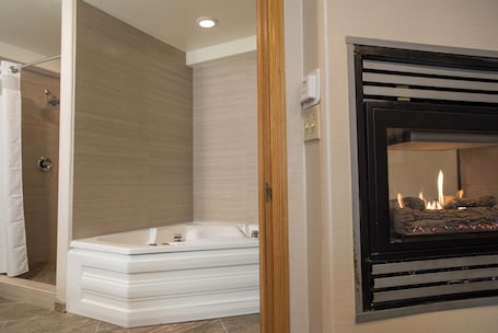 A modern bathroom with a bathtub, shower, and a fireplace.. HiMark
