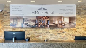 Una reception con un cartello che pubblicizza la nuova oasi benessere boutique dell'Hotel HiMark e i prossimi lavori di ristrutturazione.