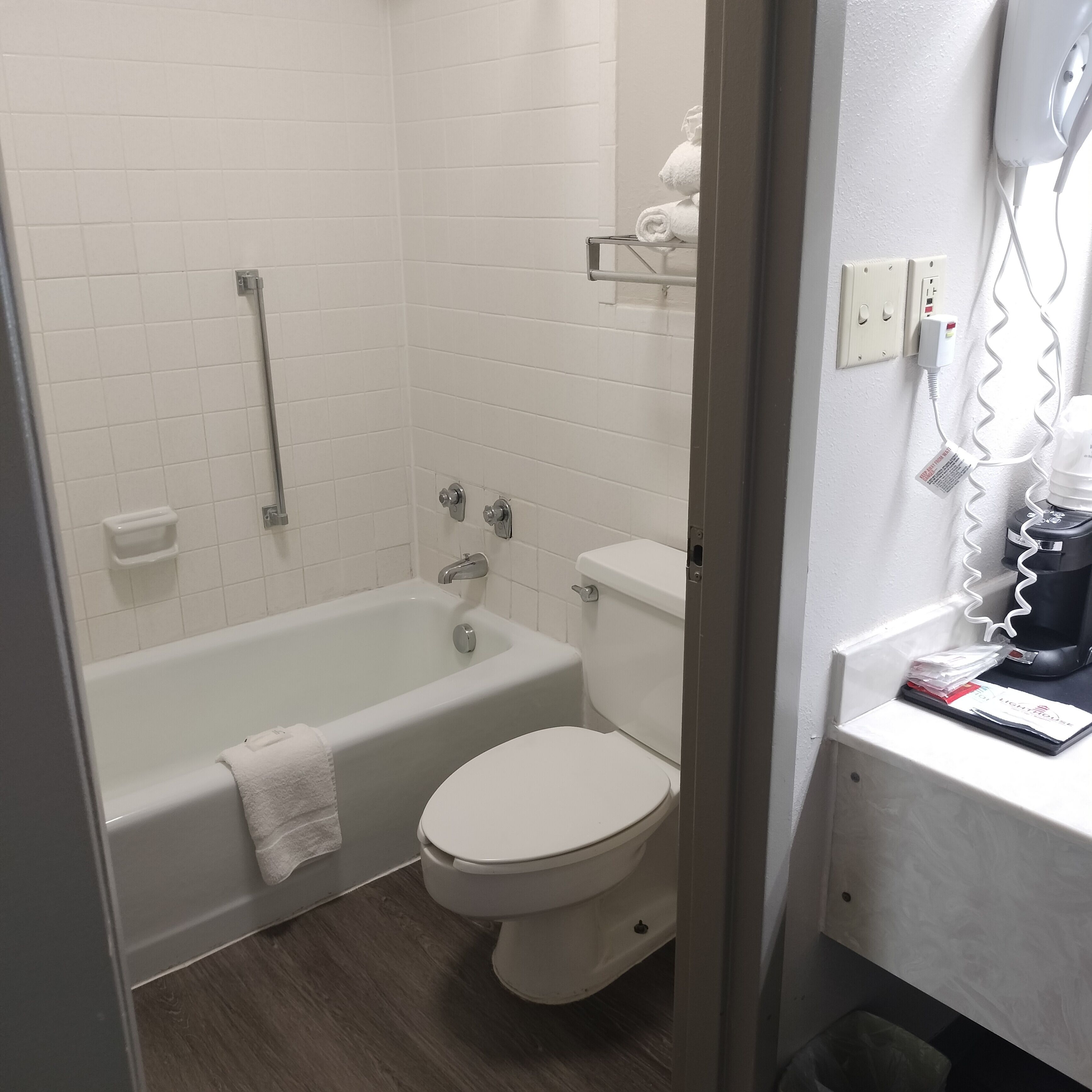 A bathroom with a bathtub, toilet, and a shower area.