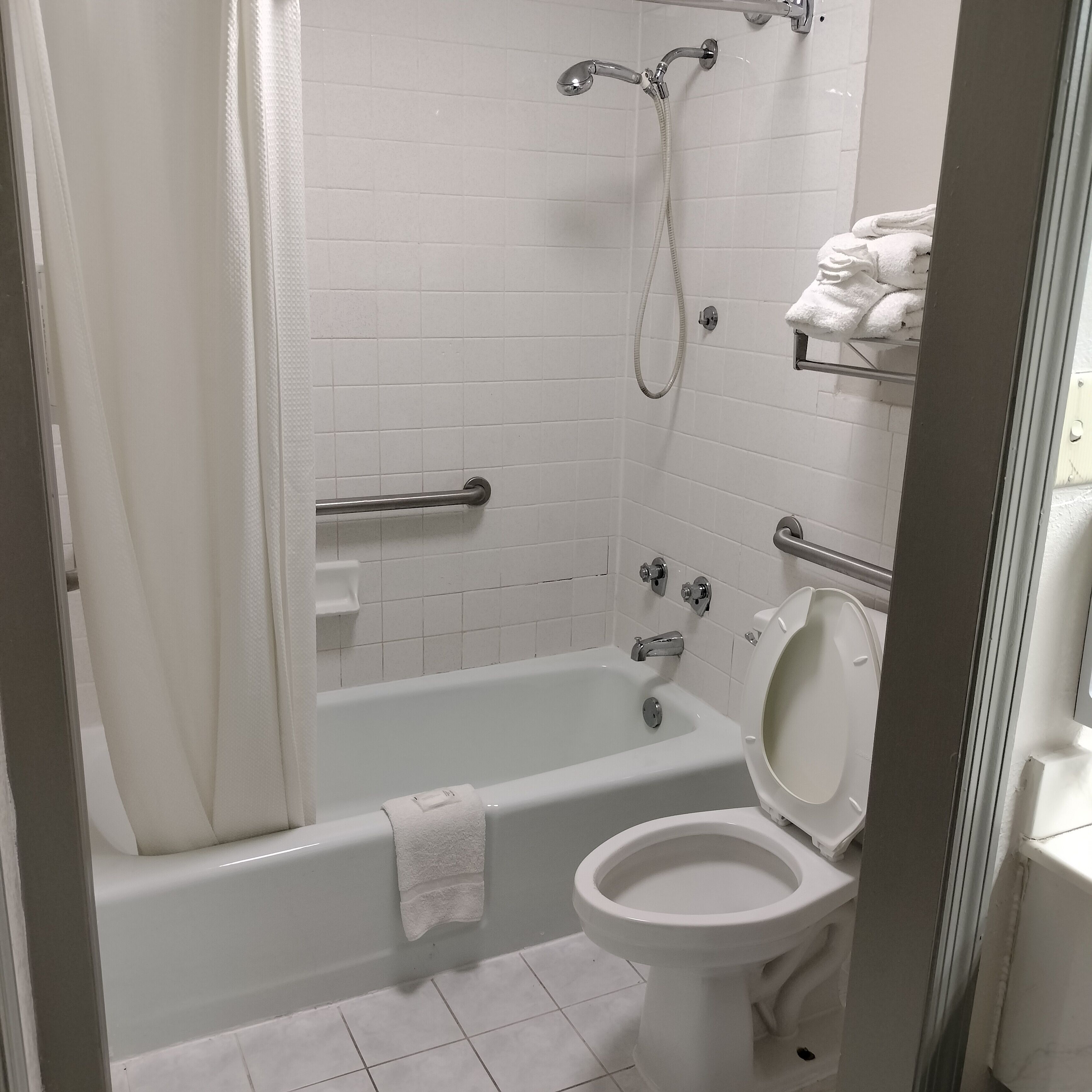 A bathroom with a bathtub, toilet, and shower.