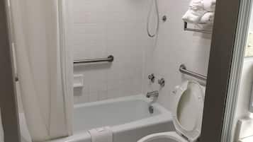A bathroom with a bathtub, toilet, and shower.