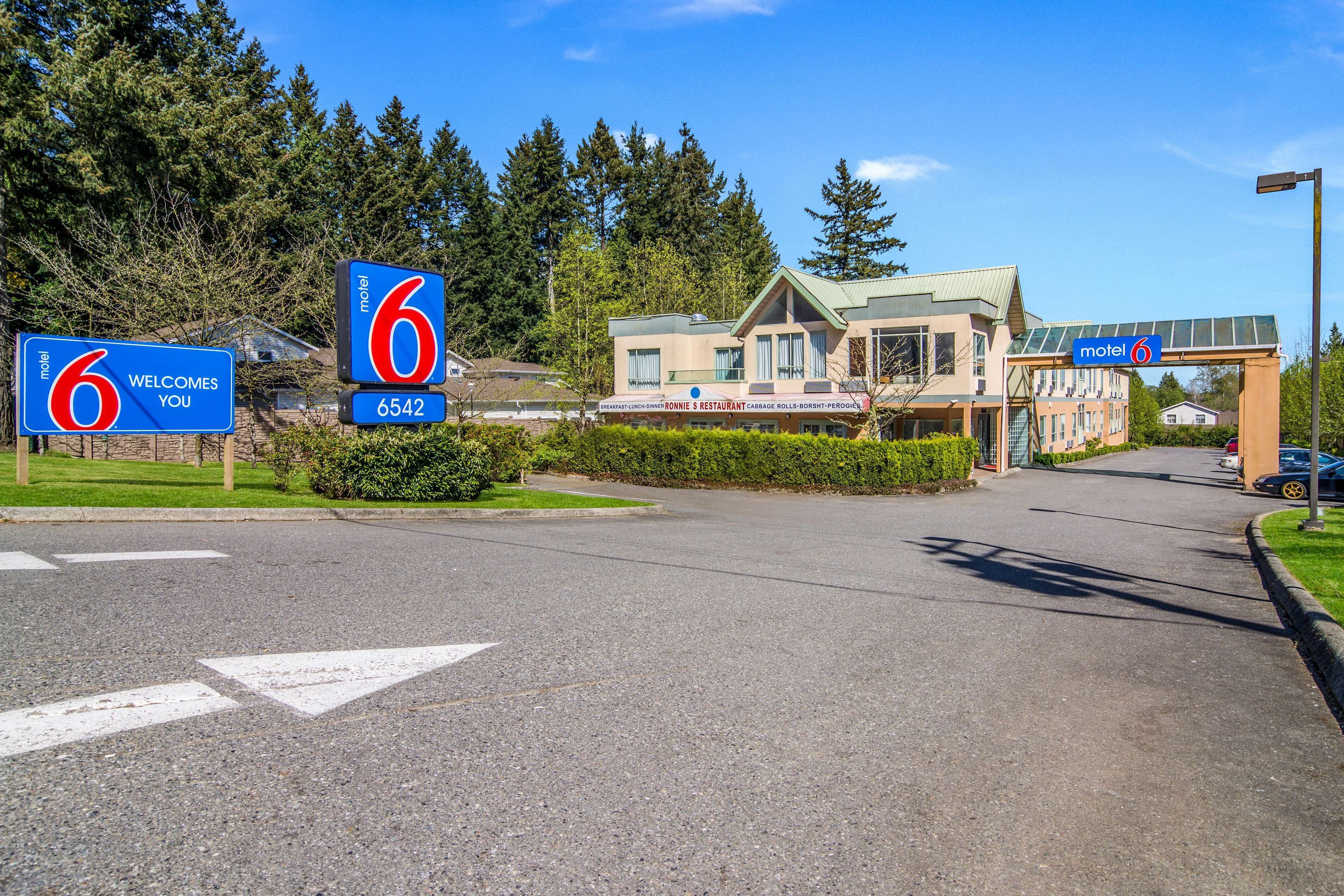 Un motel con un letrero que dice 'Motel 6' y 'le da la bienvenida'.