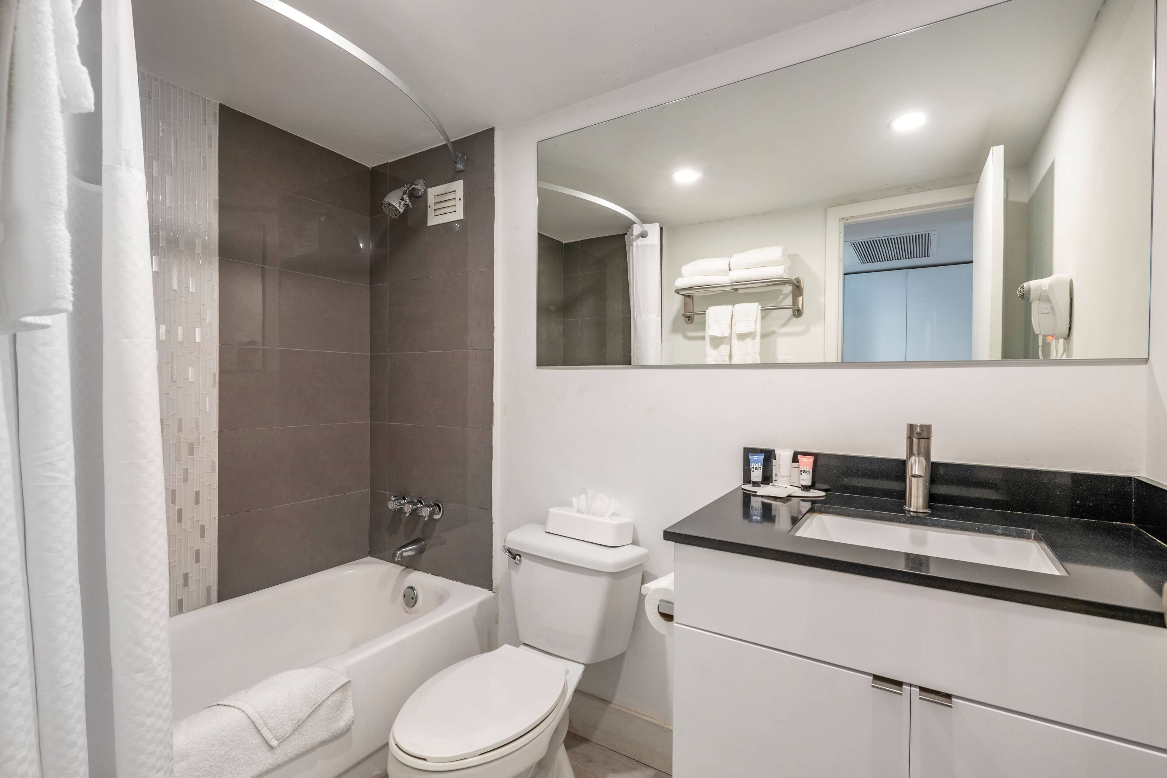 A modern bathroom with a bathtub, toilet, and sink.