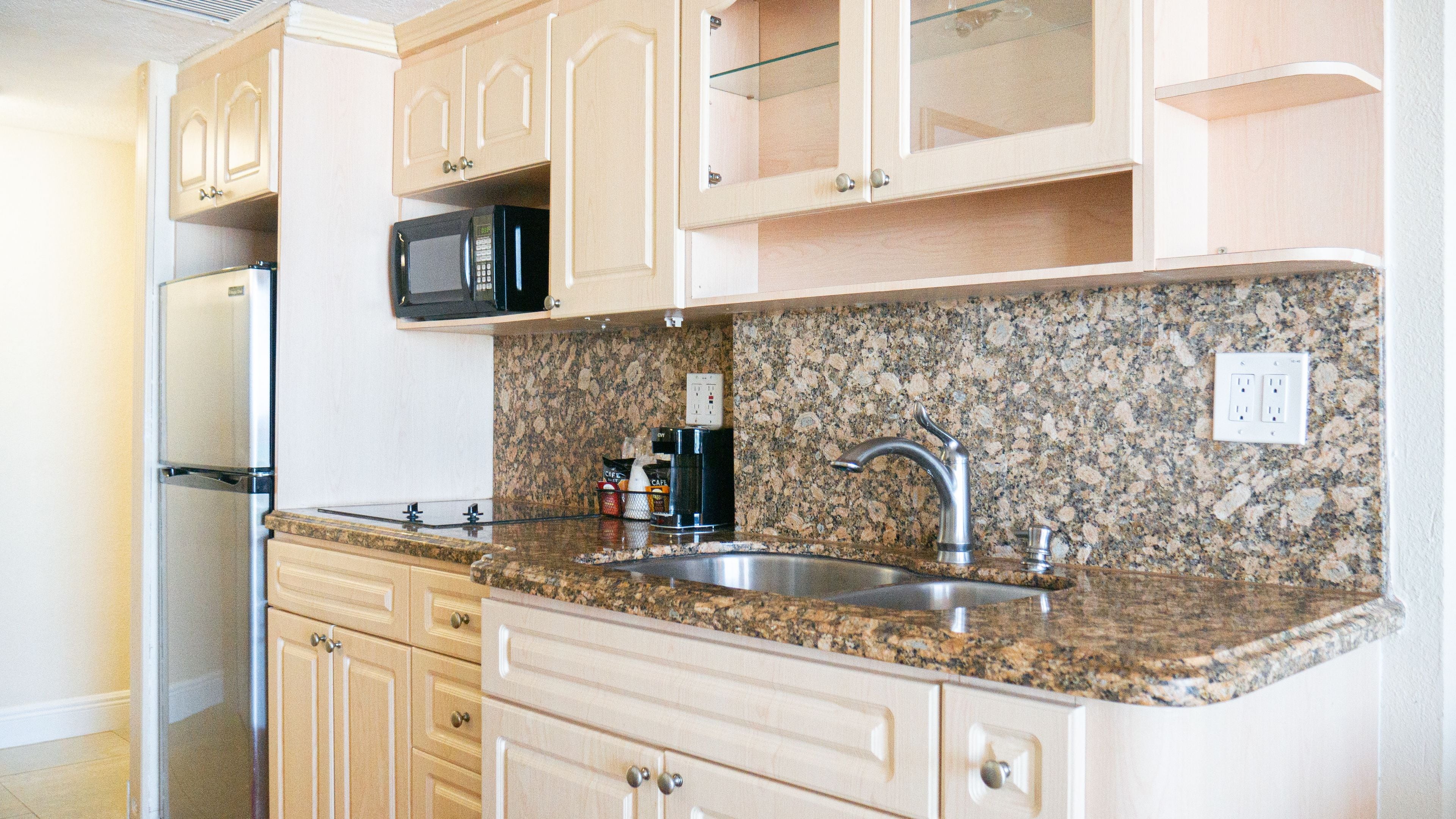 A kitchen with granite countertops, stainless steel appliances, and wooden cabinets.