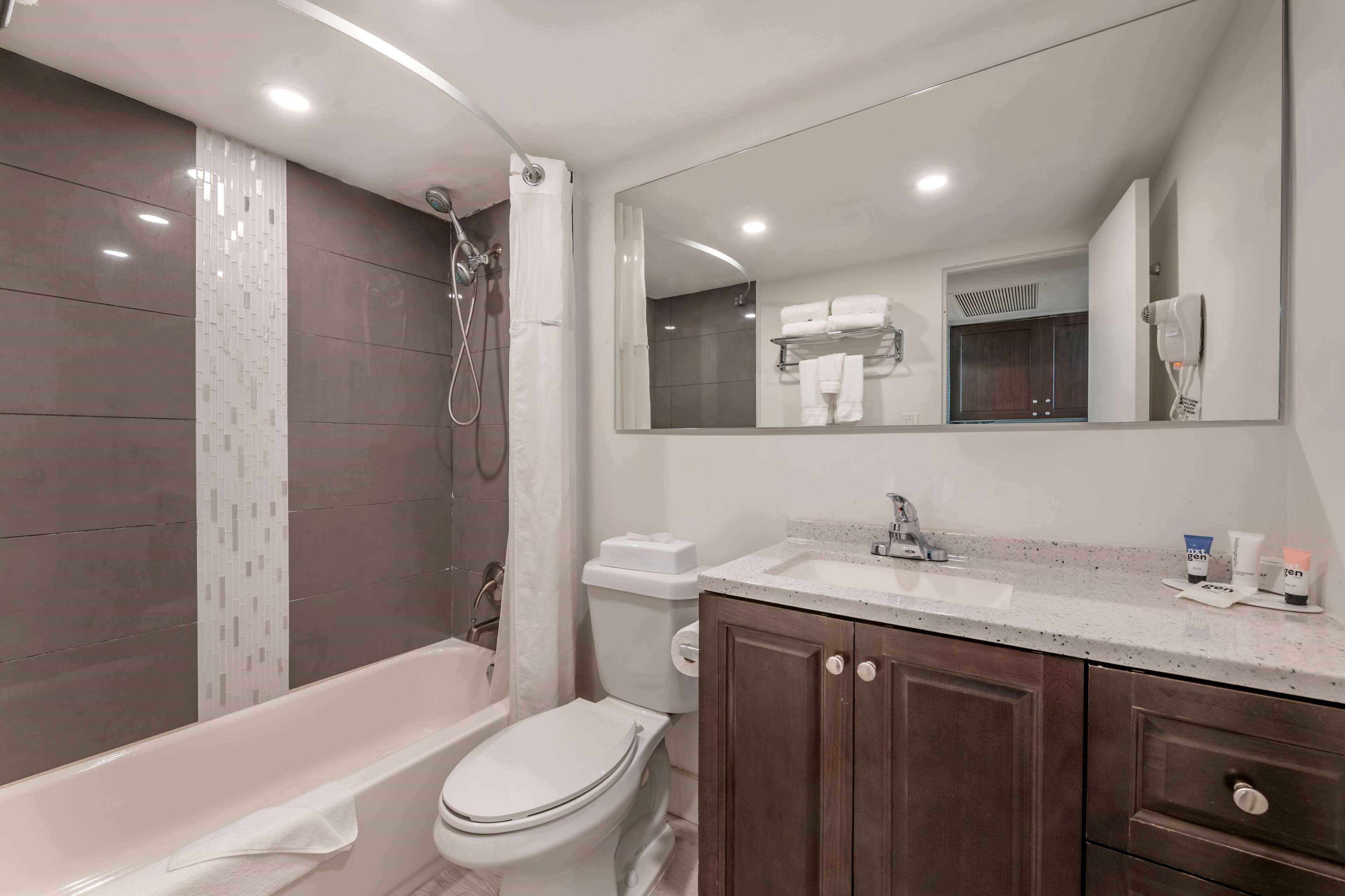 A modern bathroom with a bathtub, toilet, and sink.
