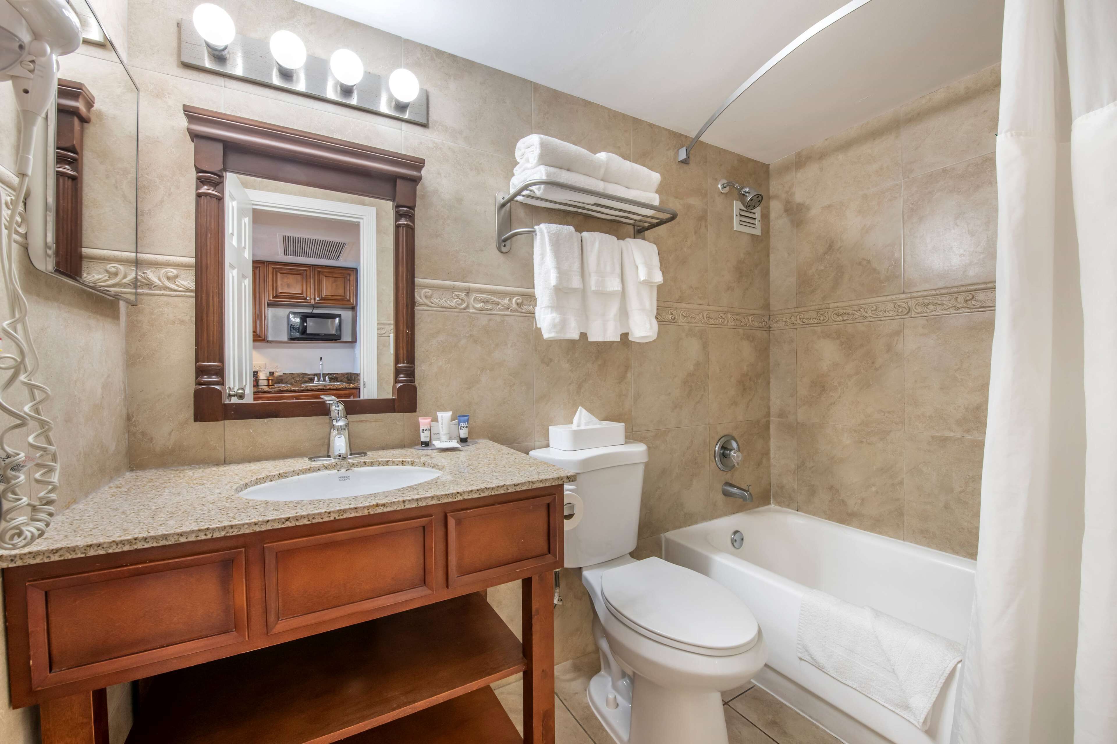 A bathroom with two sinks, a toilet, a bathtub, and a shower curtain.