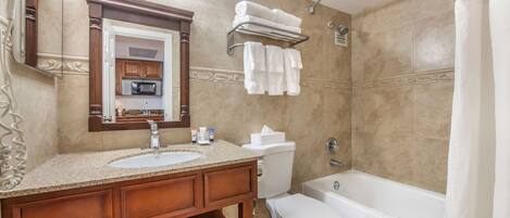 A bathroom with two sinks, a toilet, a bathtub, and a shower curtain.