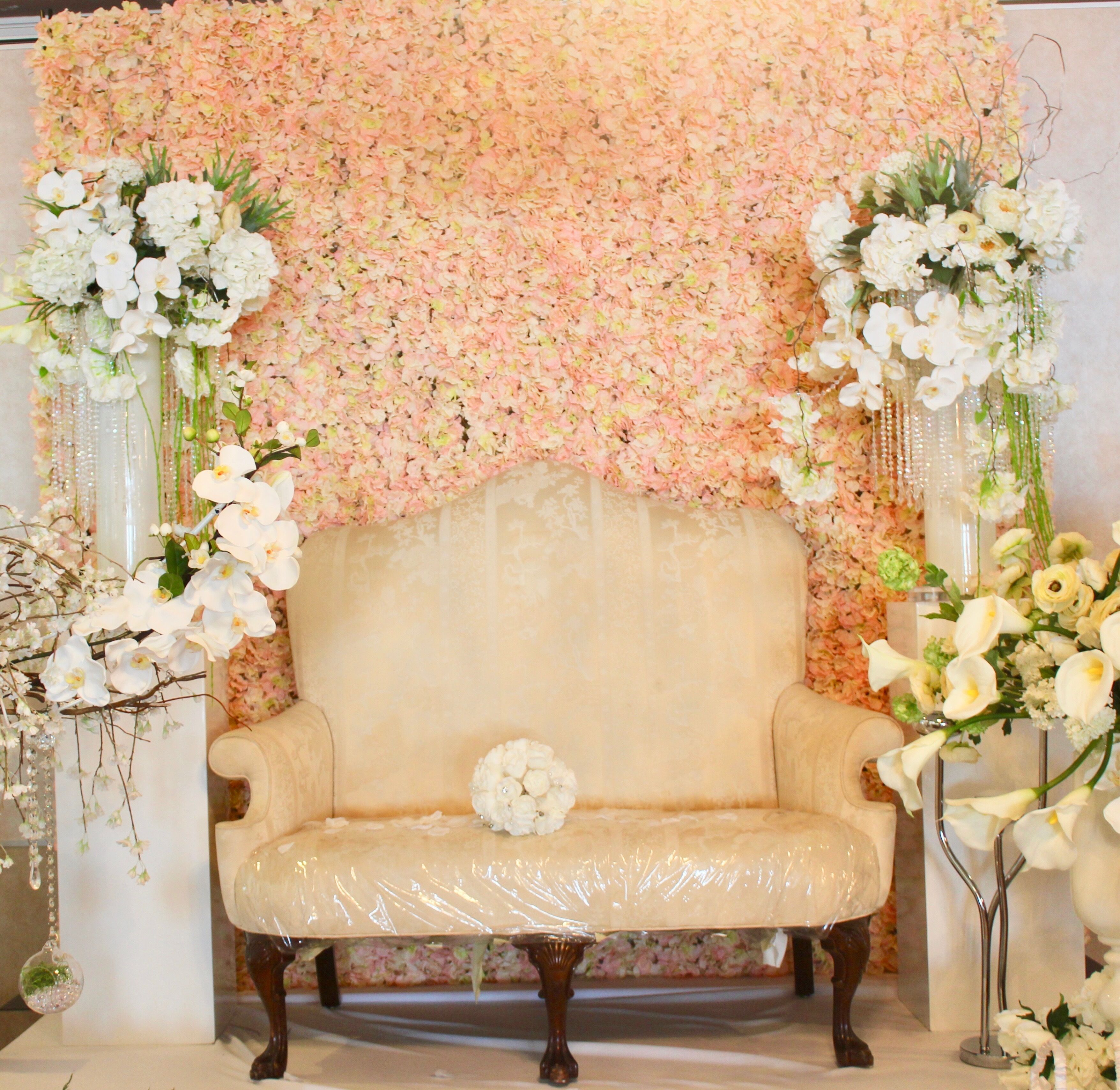 Ein Sofa mit floralem Hintergrund, einer dekorativen Vase und einem kleinen Tisch.