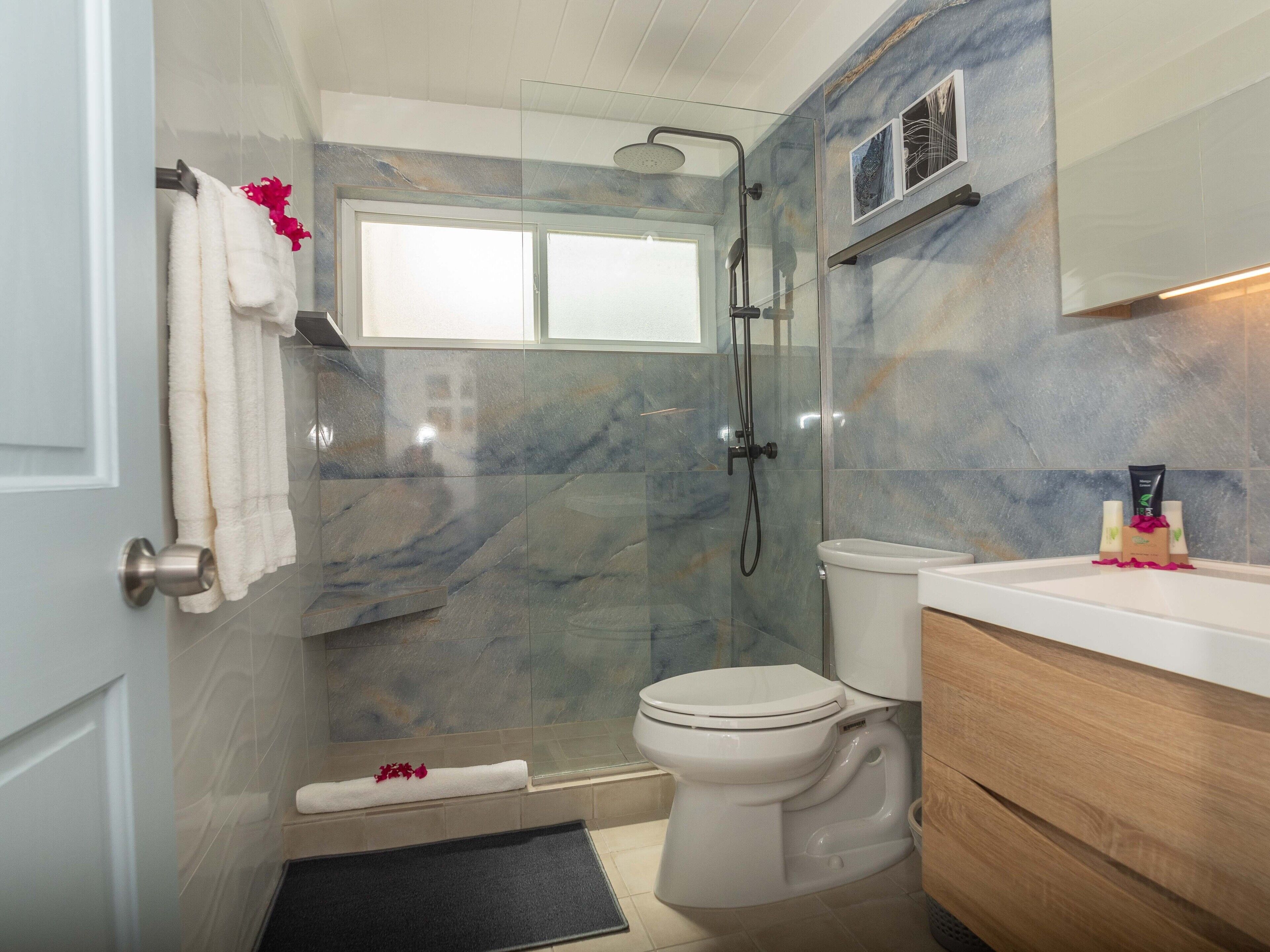 Ein modernes Badezimmer mit Dusche, Toilette und Waschtisch.