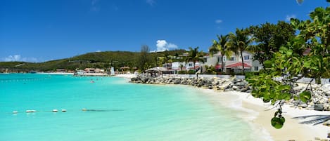 På stranden, hvit sand, solsenger og parasoller