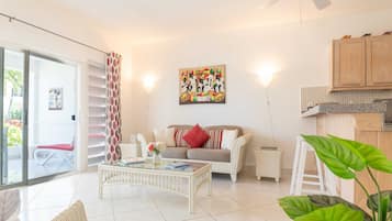 Relax in this stylish living room with a glass sliding door leading to an outdoor area, a comfortable sofa, and a coffee table.