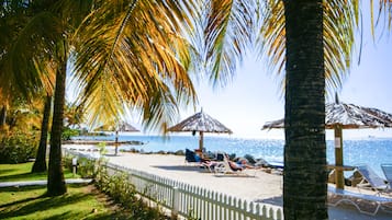 On the beach, white sand, sun loungers, beach umbrellas