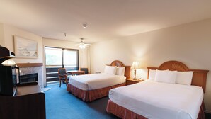 A hotel room with two beds, a desk, a chair, and a large window. - Monarch Resort (Pacific Grove)