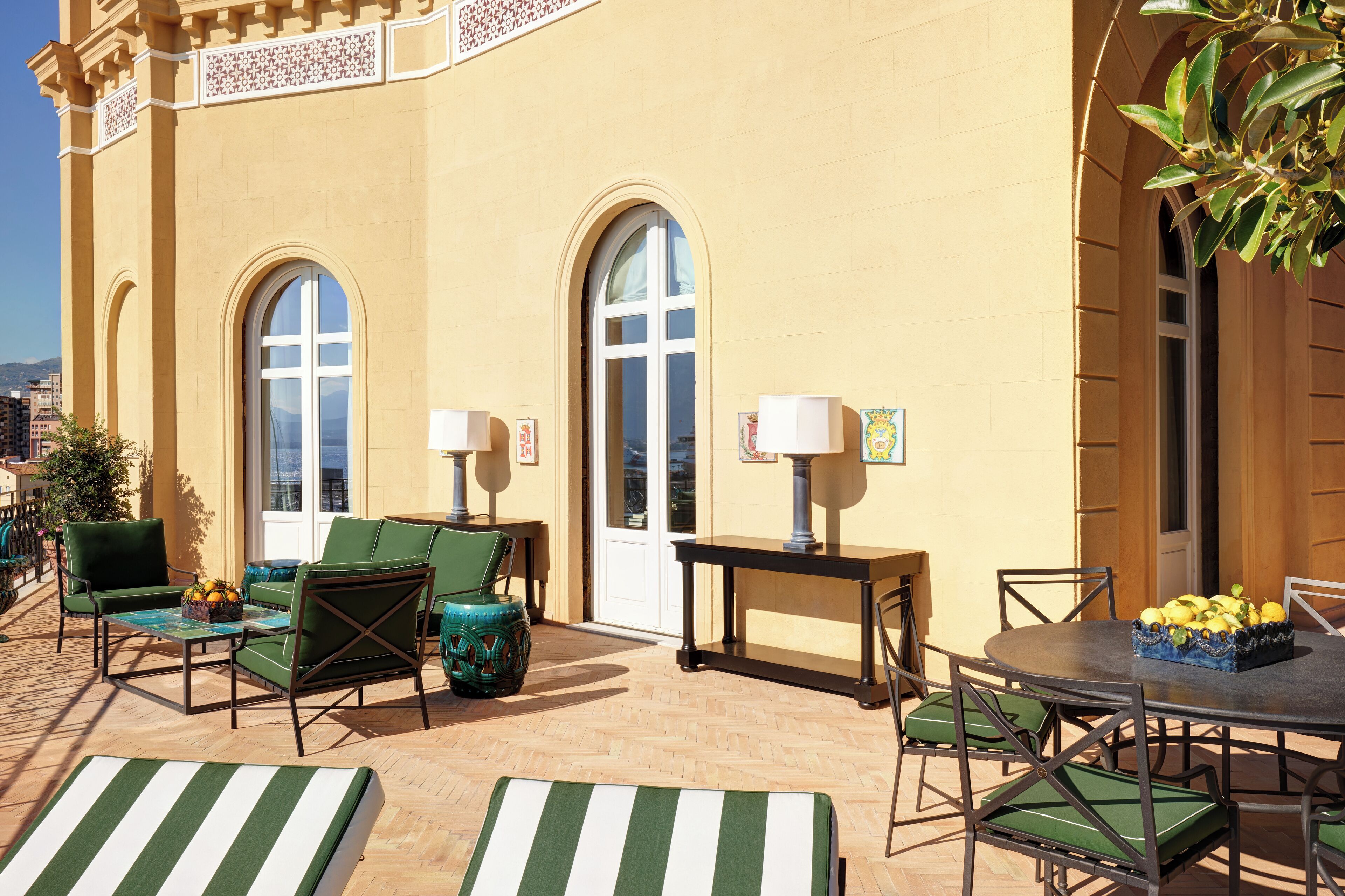 Ein Patio mit Gartenmöbeln, darunter Stühle und ein Tisch, sowie eine dekorative Vase mit Blumen.