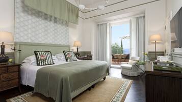 Camera d'albergo con un letto grande, due comodini, una scrivania, una sedia e vista sull'esterno.