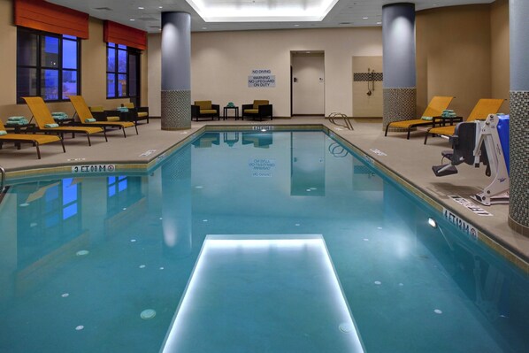 A swimming pool with lounge chairs and a sign indicating no diving.