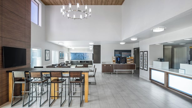 A spacious kitchen with a central island, wooden ceiling, and modern lighting fixtures. - Holiday Inn Express San Diego - SeaWorld Area by IHG (San Diego)